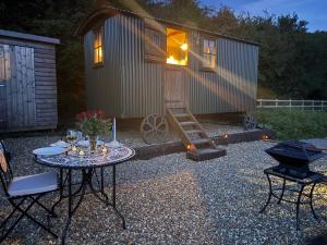 a tiny house with a table and chairs and a grill at The Drey in Trelleck