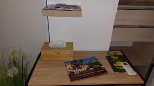 a table with two books and a remote control on it at Le patio de la place in Saint-André-de-Sangonis
