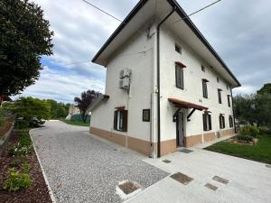 a large white building with a driveway at Casale Rûsignul in Cassegliano