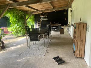 a patio with a table and chairs under awning at UNIEK Bommelgaard, guesthouse in het prachtige Rivierenland! in Hurwenen