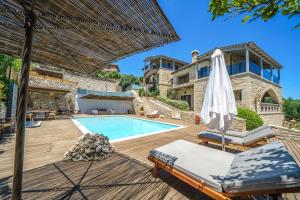 a villa with a swimming pool and a house at Asion Lithos Villas & Suites with Private Pools in Kato Asites