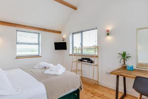 a bedroom with a bed and a desk and windows at 4 Bed in Bugle oc-f34175 in Penwithick
