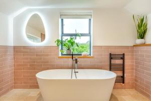 a bathroom with a white tub and a window at 4 Bed in Bugle oc-f34175 in Penwithick +23 photos