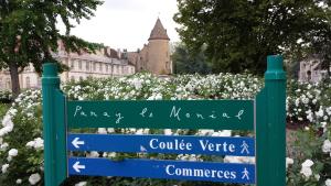 a sign in front of a building with white flowers at Maison Corcovado in Paray-le-Monial