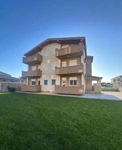 a large building with a green lawn in front of it at Elit Apartmani in Ulcinj