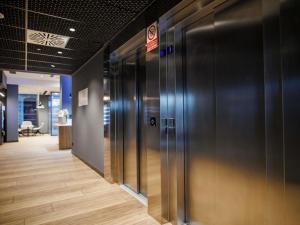 a row of elevators in an office with a no smoking sign at ibis budget Logroño Centro in Logroño +135 photos