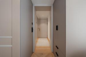 a hallway with white cabinets and a hallway leading to a door at ODA Suites - self check-in apartments, old town in Lucerne