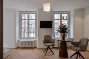 a living room with a table and two chairs and a television at ODA Suites - self check-in apartments, old town in Lucerne