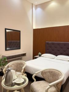 a hotel room with a bed and two chairs at The Lamendriea Hotel in Kalagedihena