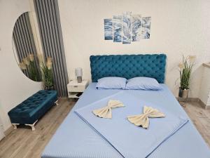 a bedroom with a blue bed and a blue couch at Apartman Centar Lazic 1 in Šid