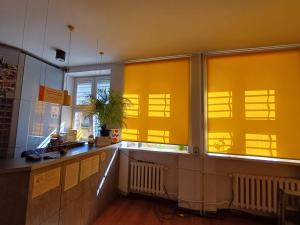 a kitchen with yellow blinds on the windows at Tatamka Hostel in Warsaw