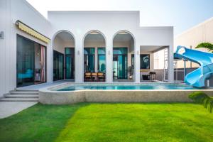 a swimming pool with a slide in a house at April Pool Day Villa Cha-am in Cha Am