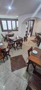 a restaurant with wooden tables and chairs and windows at Pousada dos Bandeirantes in Ouro Preto