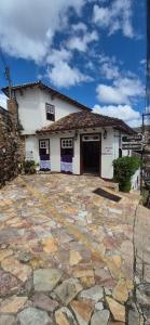 a building with a stone driveway in front of it at Pousada dos Bandeirantes in Ouro Preto