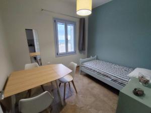 a small room with a bed and a table and chairs at Mosaic house by the sea in Kini