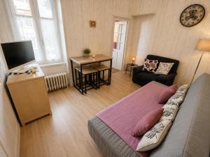 a room with a bed and a television and a table at Aux Roses in Saint-Honoré-les-Bains