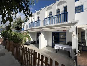 a white house with blue balconies and a fence at Playmar6970 in Maspalomas
