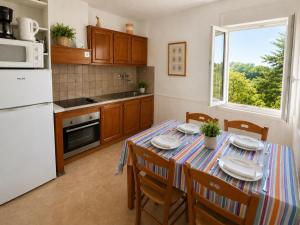 a kitchen with a table with plates on it at Aux Coquelicots in Saint-Honoré-les-Bains