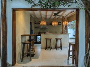 a bar in a kitchen with stools and a mirror at Tamu Tamu Boutique Hotel in Pwani Mchangani