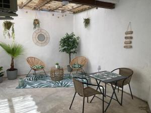 a patio with a table and chairs and plants at Le patio de la place in Saint-André-de-Sangonis
