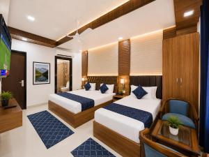a hotel room with two beds and a television at Urben BellaMount Hotel - Free Airport and Aerocity Pick Up & Drop in New Delhi