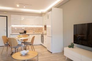 a kitchen and living room with a table and chairs at Boheme Apartment in Leptokarya