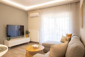 a living room with a couch and a tv at Boheme Apartment in Leptokarya