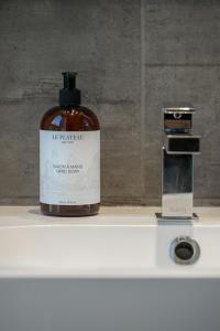 a bottle of soap sitting on top of a sink at Lofts Le Plateau in Montreal +34 photos