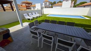 a patio with a table and chairs and a swimming pool at Chalet Laguna Place in Chipiona
