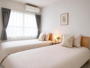 two beds in a room with a window at 幸・3 in Osaka
