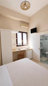 ein Schlafzimmer mit einem Bett, einem Schreibtisch und einer Uhr in der Unterkunft B&B Li Ccoti in Cannole