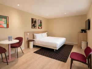a hotel room with a bed and a table and chairs at Numa Brighton Pavilion in Brighton & Hove