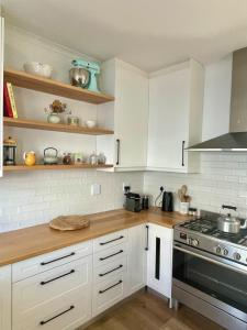 a kitchen with white cabinets and a stove at The Kite Manor in Langebaan