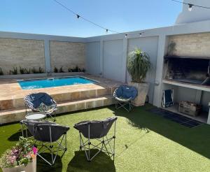 a patio with chairs and a swimming pool at The Kite Manor in Langebaan