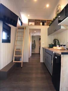 a small kitchen with a staircase in a tiny house at Tiny House avec jacuzzi privé - calme et nature in Grabels