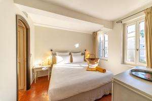 a bedroom with a large white bed and a sink at Hotel la Ponche in Saint-Tropez +100 photos