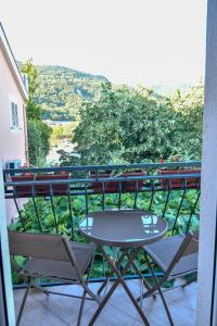 a table and chairs on a balcony with a view at Guest house Šebelj in Budva