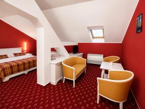 a hotel room with a bed and two chairs at Park Hotel Tartuf in Beladice