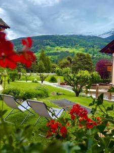 two chairs sitting on the grass in a garden at Casa Clus Bormio apartments 3 in Valdisotto