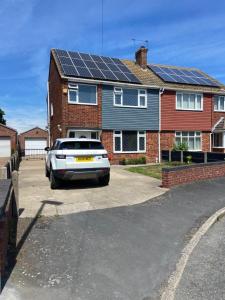 a car parked in front of a house with solar panels at 3-Bed Retreat Perfect Contractors & Leisure Stays Onsite Parking in Messingham