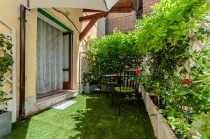 a patio with green grass and a table and chairs at Attimo Green House in Lonato