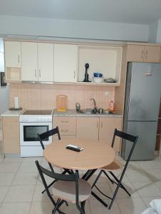 a kitchen with a table and chairs and a refrigerator at Central 26 apartment in Kalamata in Kalamata