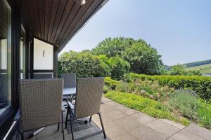 a patio with a table and chairs on a porch at Ferienhaus Hennesee in Meschede