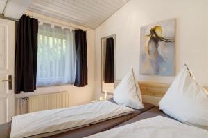 a bedroom with two beds and a window at Ferienhaus Hennesee in Meschede