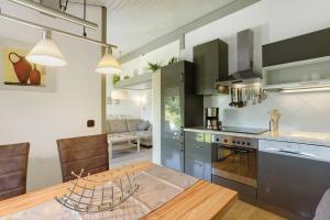a kitchen with a wooden table and a dining room at Ferienhaus Hennesee in Meschede