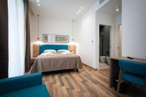 a bedroom with a bed and a blue chair at I Segreti del Chiostro - Le Dimore in Palermo