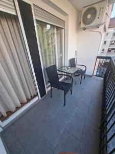 a patio with chairs and a table on a balcony at Apartman Mirjana 2 spavace odvojene sobe in Banja Luka