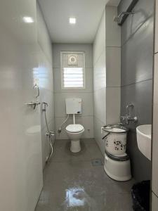 a bathroom with a toilet and a sink at Chandralok Service Apartments in Kolhapur