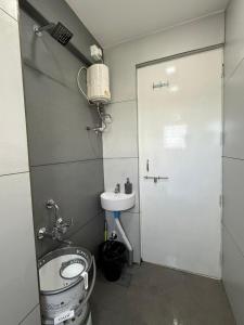 a small bathroom with a toilet and a sink at Chandralok Service Apartments in Kolhapur