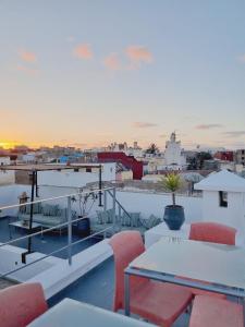 a balcony with tables and chairs and a view of a city at Riad7 in Azemmour